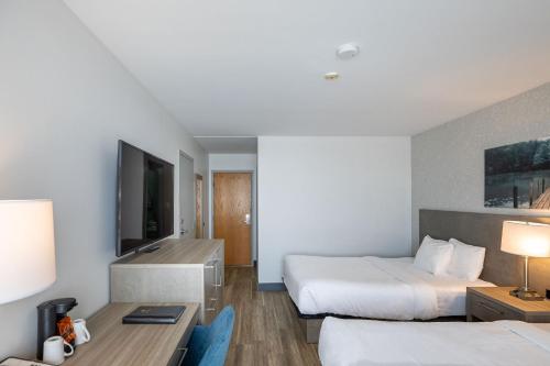 une chambre d'hôtel avec deux lits et un bureau dans l'établissement Repotel Henri IV Québec, à Québec