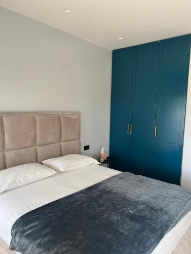 a bedroom with a large bed with blue cabinets at D'azur Home in Vlorë