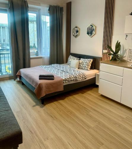 a bedroom with a bed and a large window at Exclusive Apartments Smolna in Warsaw