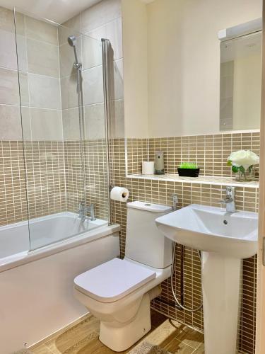 a bathroom with a toilet and a sink and a tub at Spacious Stay made for Contractors & Families ! 3 Bedroom House 2 Bathroom in Reading up to 3 Free Parking !! in Reading