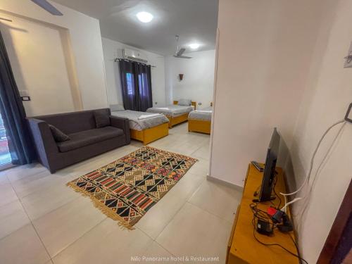a living room with a couch and a tv at Nile Panorama Hotel in Luxor