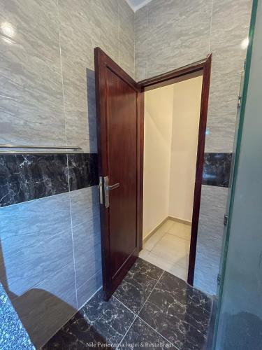 a bathroom with a wooden door and a glass doorway at Nile Panorama Hotel in Luxor