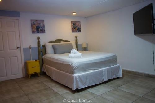 a bedroom with a bed and a flat screen tv at Casa Lomas in Tegucigalpa