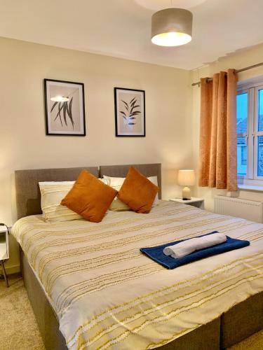 a bedroom with a large bed with orange pillows at Spacious Stay made for Contractors & Families ! 3 Bedroom House 2 Bathroom in Reading up to 3 Free Parking !! in Reading