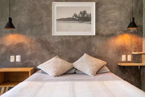 a bedroom with a bed with two pillows on it at Sayula HoME in Sayulita