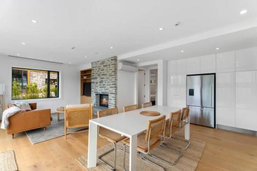 a kitchen and living room with a white table and chairs at Lakeview Luxury Villa in Wanaka