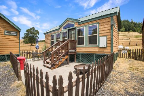 a wooden house with a wooden fence and a deck at Mendocino Redwoods RV Resort in Willits