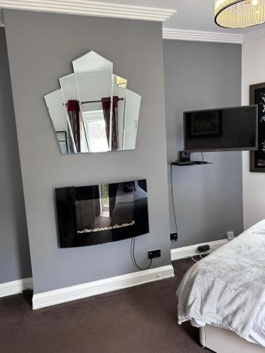 a bedroom with a mirror on the wall at Art Deco One Bedroom Guest Apartment in Yapton