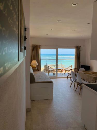 a bedroom with a bed and a view of the ocean at Espardell Beachfront Stay - Ocean Breeze & Sunrise in Es Pujols