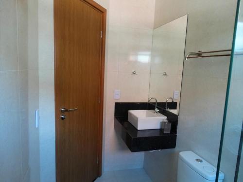 een badkamer met een wastafel en een spiegel en een toilet bij Casa na Serra - paz e natureza in Chã Grande