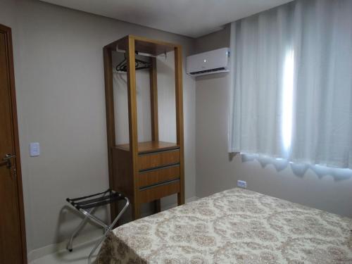 een slaapkamer met een bed en een houten kast bij Casa na Serra - paz e natureza in Chã Grande