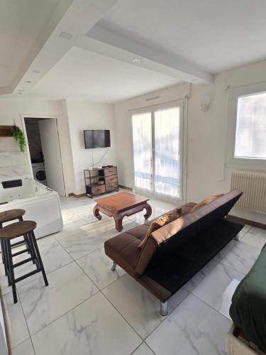un salon avec un canapé et une table dans l'établissement Exotic Spa Balcon Wifi Netlfix Parking, à Belfort