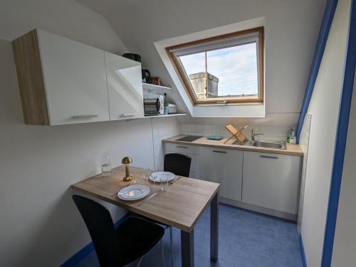 une petite cuisine avec une table en bois et un évier dans l'établissement Charmant T2 à Cancale proche du sentier douanier, à Cancale