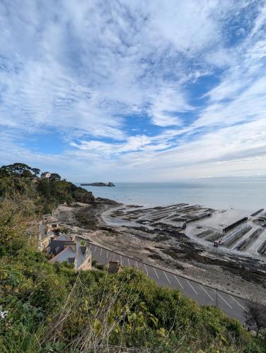 - une vue sur la plage et l'océan par une journée nuageuse dans l'établissement Charmant T2 à Cancale proche du sentier douanier, à Cancale