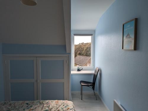 une chambre avec un lit, une chaise et une fenêtre dans l'établissement Charmant T2 à Cancale proche du sentier douanier, à Cancale
