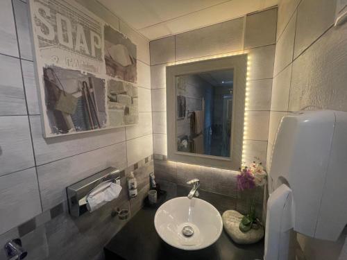 a bathroom with a sink and a mirror at Appart' Spa et Sauna Privatif Au Cœur De Beaune in Beaune
