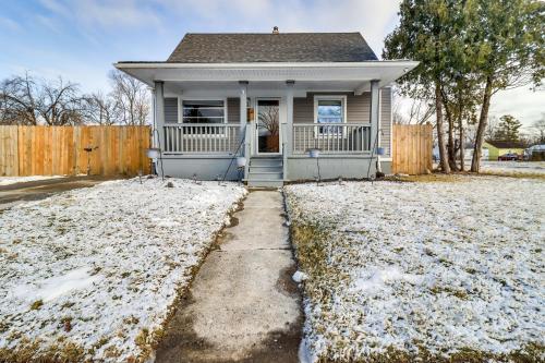 a small house with snow on the ground at 1 Mi to Rouge Park Home with Fenced Yard and Deck in Detroit