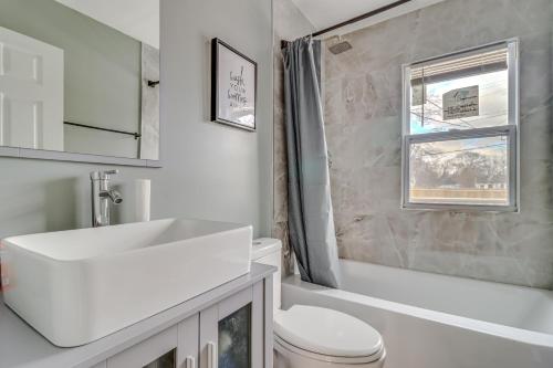 a white bathroom with a sink and a toilet at 1 Mi to Rouge Park Home with Fenced Yard and Deck in Detroit