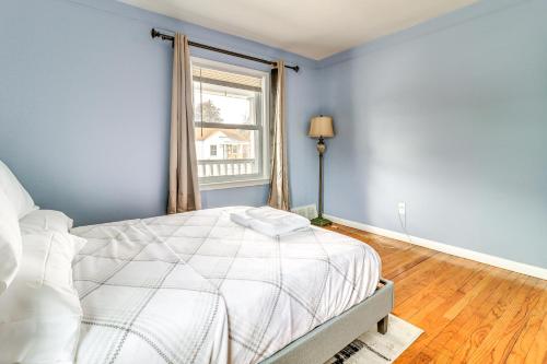 a bedroom with a white bed and a window at 1 Mi to Rouge Park Home with Fenced Yard and Deck in Detroit