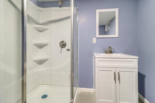 a white bathroom with a shower and a sink at 1 Mi to Rouge Park Home with Fenced Yard and Deck in Detroit