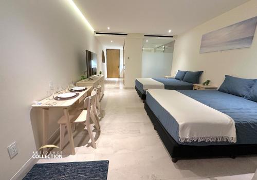 a hotel room with two beds and a table and a bed at Residence by Mio Nuevo Vallarta 103-C in Nuevo Vallarta