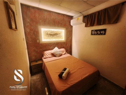 a small room with a bed and a window at Casa Scarlett in Cartagena de Indias