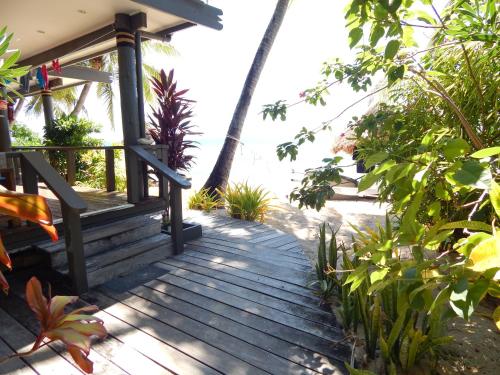 a wooden porch of a house with the ocean in the background at Octopus Resort in Nalauwaki