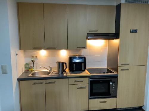 a small kitchen with a sink and a microwave at The Stalle in Brussels
