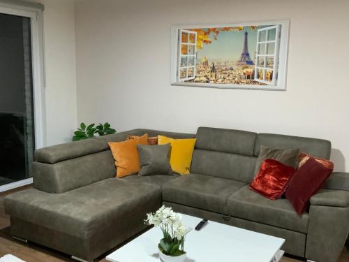 a living room with a gray couch with colorful pillows at The Stalle in Brussels