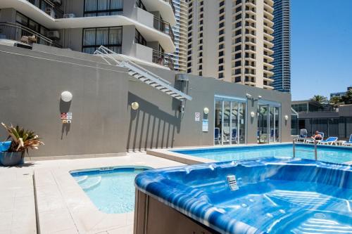 a swimming pool in a building with two tall buildings at High Level 1BR Apartment 1 MIN to Beach in Gold Coast