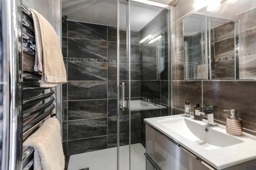 une salle de bain avec un lavabo et une douche en verre dans l'établissement Sublime appartement calme et cosy, à Saint-Raphaël