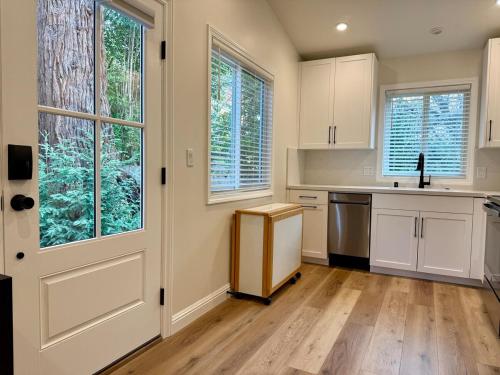 a kitchen with white cabinets and a door at Chic and Petite 1-Bedroom ADU with Private Entrance in peaceful Orinda in Orinda