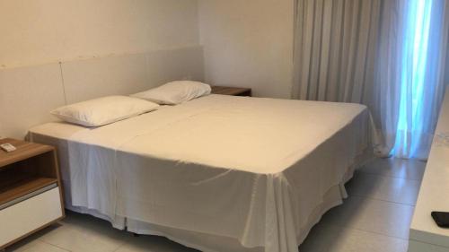 a bedroom with a bed with a white bedspread at Laguna verde residence in Aquiraz
