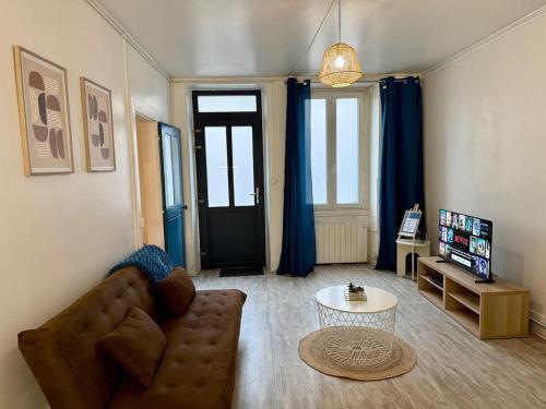 a living room with a couch and a table at Le Canard du Berry - Wifi - Centre Ville in Bourges