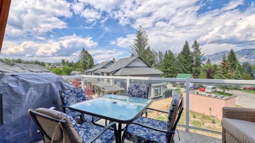 a patio with a table and chairs on a balcony at Heron Point by StayIn in Invermere