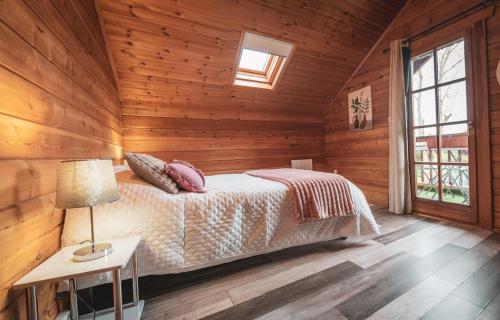 une chambre avec un lit dans une pièce en bois dans l'établissement Chalet proche Fontainebleau senart Paris, parking gratuit, à Réau
