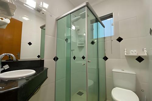 a bathroom with a glass shower and a toilet at Apartamento aconchegante próximo à Faculdade in Araxá