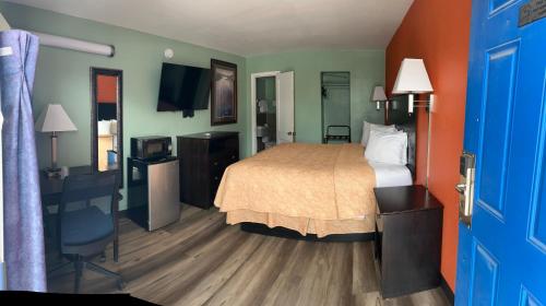 a hotel room with a bed and a blue door at Town & Country Motel in Sioux City