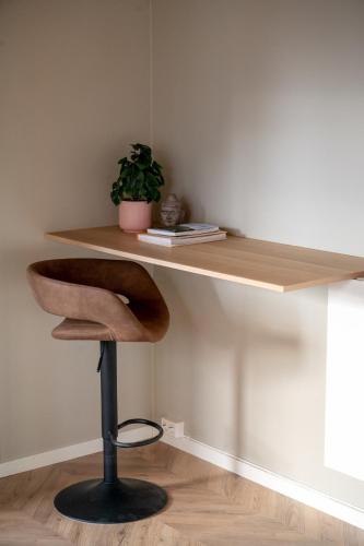 a wooden desk with a chair and a plant at 3F - In the heart of Trondheim in Trondheim