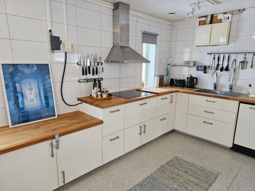 a kitchen with white cabinets and wooden counter tops at The Northern Light Apartment in Jukkasjärvi