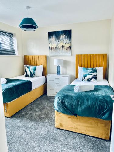 Un dormitorio con dos camas con sábanas azules y blancas. en Spacious 3BR Home in Colchester, with Private Parking, en Colchester