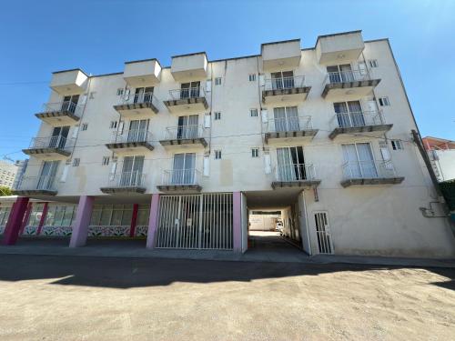 a large white building with balconies on it at Hotel Ciprés Puebla in La Concepción