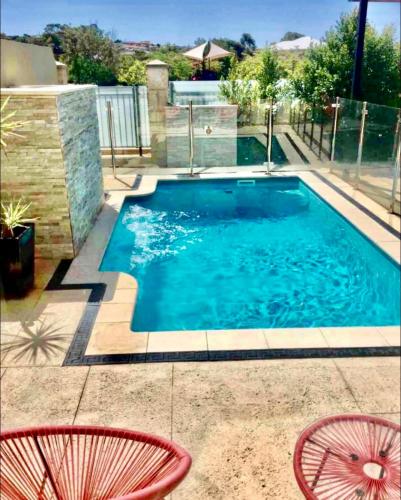 a swimming pool with two chairs and a table at Luxury Villa W Pool & Spa 5 BEDROOMS in Coogee