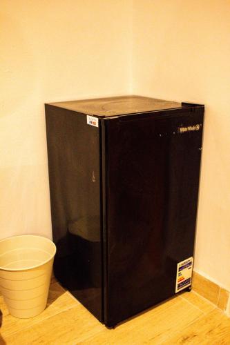 a black microwave sitting on the floor next to a bucket at Ithaka Raml Hostel in Alexandria