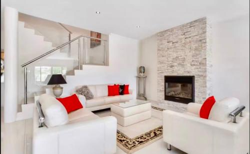 a living room with white furniture and a fireplace at Luxury Villa W Pool & Spa 5 BEDROOMS in Coogee