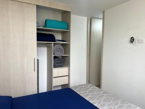 a bedroom with a blue bed and a closet at Apartamento TERMINAL DE TRANSPORTE, CABLE AEREO, DOLLARCITY, D1 in Manizales
