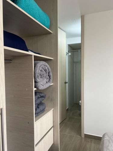 a walk in closet with wooden shelves in a room at Apartamento TERMINAL DE TRANSPORTE, CABLE AEREO, DOLLARCITY, D1 in Manizales