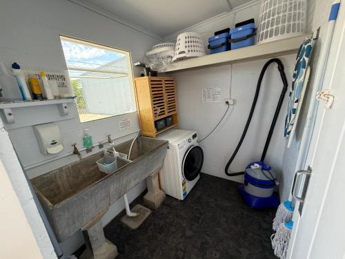 a bathroom with a sink and a washing machine at Marine Parade Holiday Unit 2 in Port Vincent