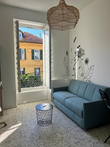 un salon avec un canapé bleu et une fenêtre dans l'établissement Studio Les Sources, à Nice