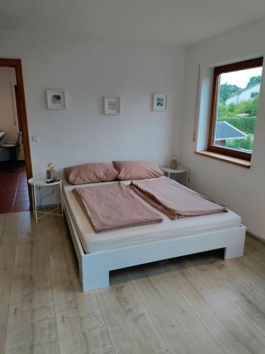 a white bed in a room with a window at Gemütliche Wohnung in Oberteuringen in Oberteuringen